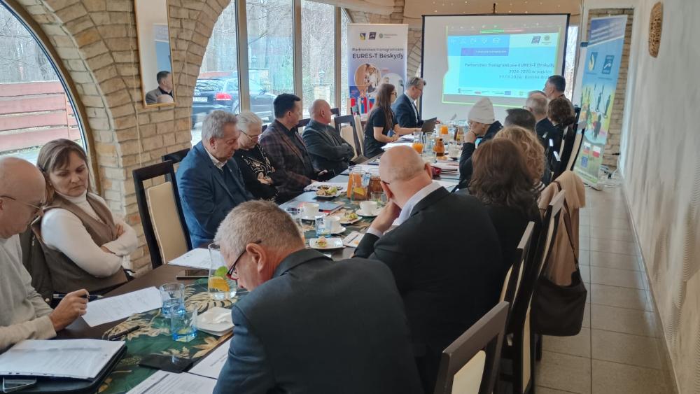 Przedstawiciele partnerstwa Eures-T Besydy na spotkaniu. W tle widać slajd prezentacji.